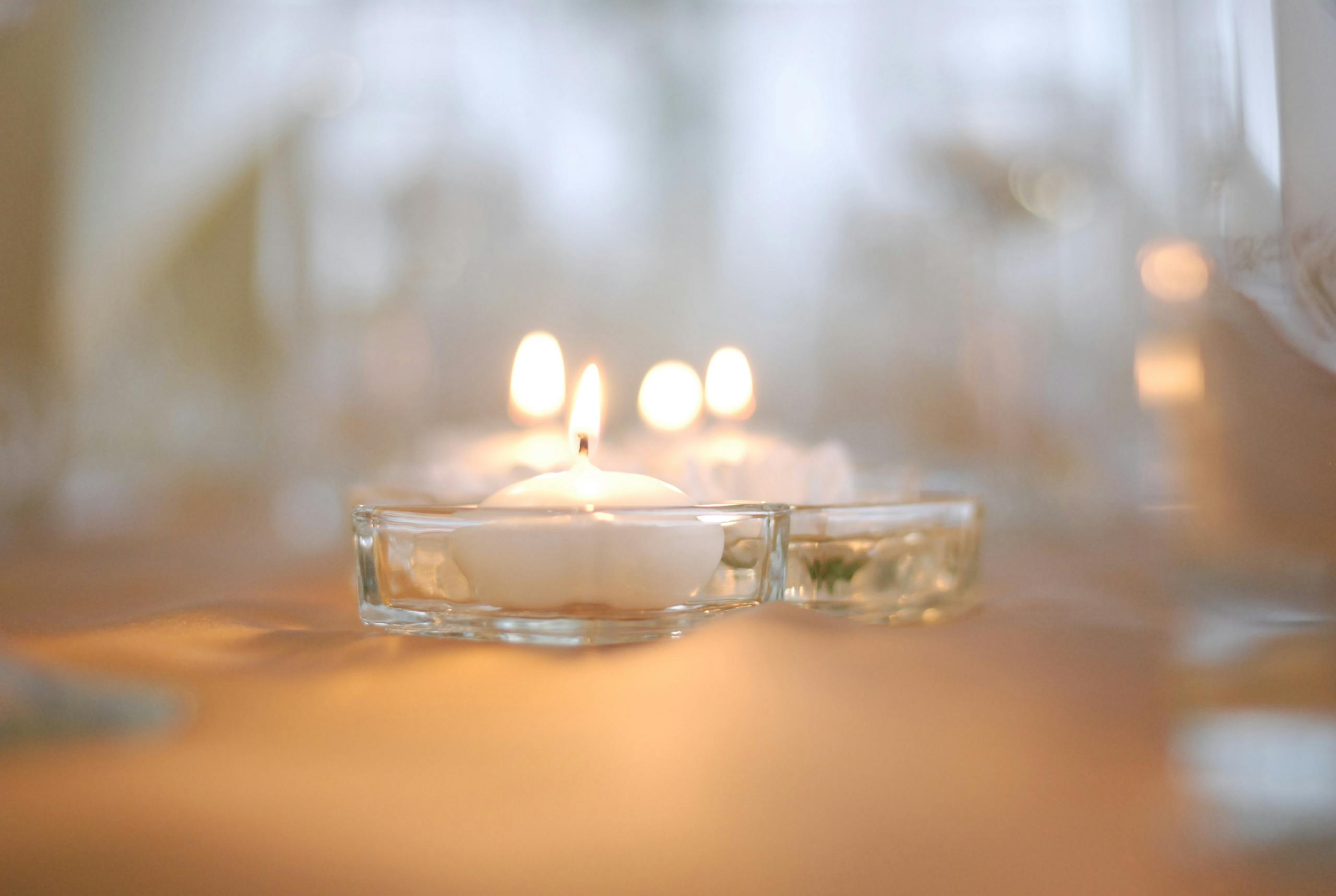 Soft focus image of lit candles creating a warm and intimate atmosphere, perfect for weddings or romantic settings.